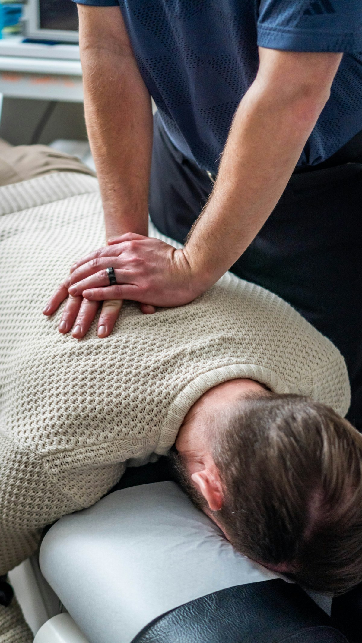 Zabieg chiropraktyczny — praca manualna na plecach pacjenta